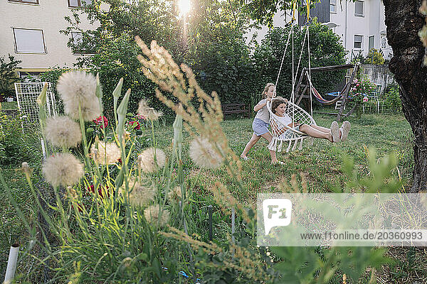 Zwei Teenager spielen im Sommergarten in der Nähe des Hauses. Landleben.