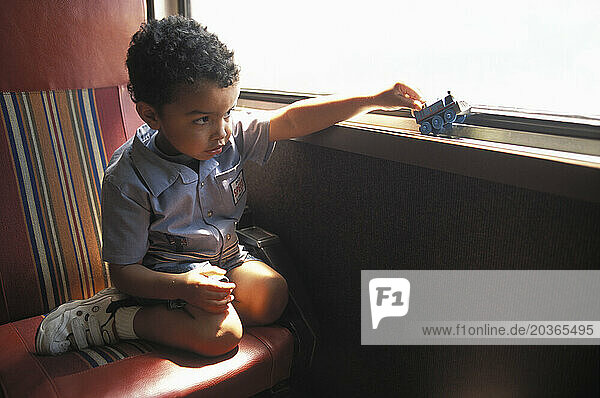 A boy playing with a toy train.