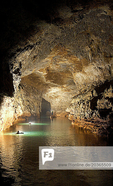 Cave explorers floating downstream in a cave in New Britain