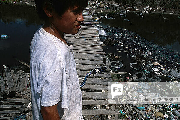 Silvestre Tamez  13 riding bicycle across a wastewater canal in Matamoros  Mexico.