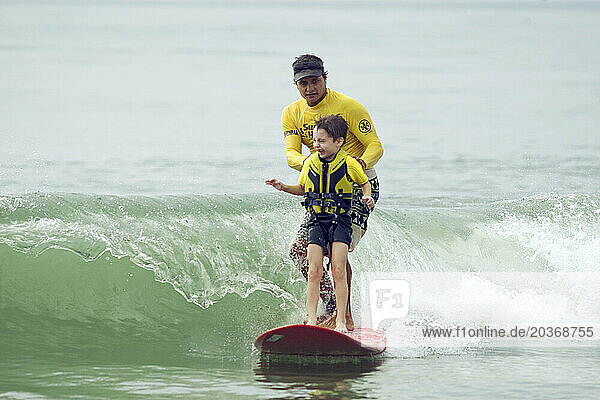 Surfer's Healing with Autistic children riding waves at Wrightsville Beach  NC