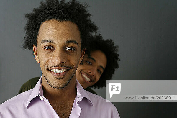 Two African American brothers smile.