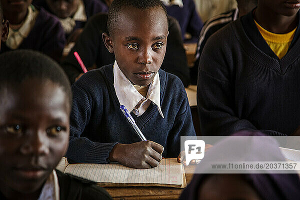 Tanzanian student sitting at desk in school
