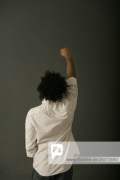 African American man with huge afro holds fist in air.
