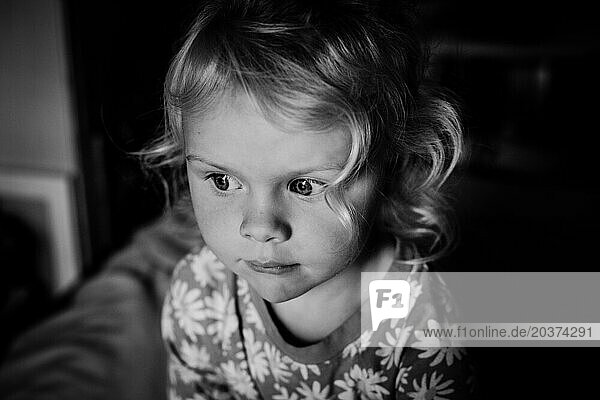 Casual black and white portrait of toddler girl with curly hair
