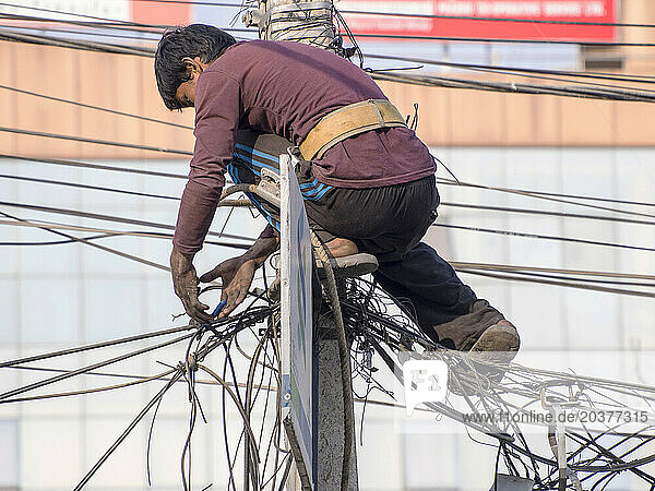 Electrician on top of utility pole  Kathmandu  Nepal