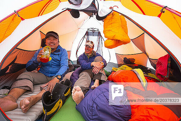 Two Mountaineers Are Having A Good Conversation While Resting In A Tent At Kahiltna Glacier