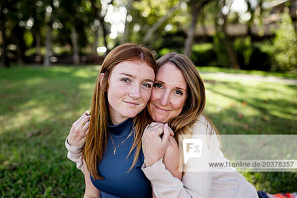 Loving Mom Hugging Teenage Daughter in Park in San Diego