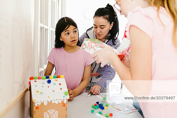 Multi racial asian and blond girls work on winter crafts and colors