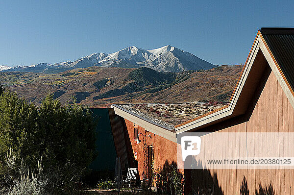 View of Mt. Sopris in the fall beyond a sustainable country home with a living roof in the Roaring Fork Valley  CO.