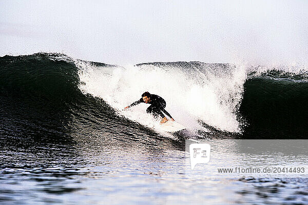 A male surfer rides a 7’6� surfboard while surfing in Ventura, California.