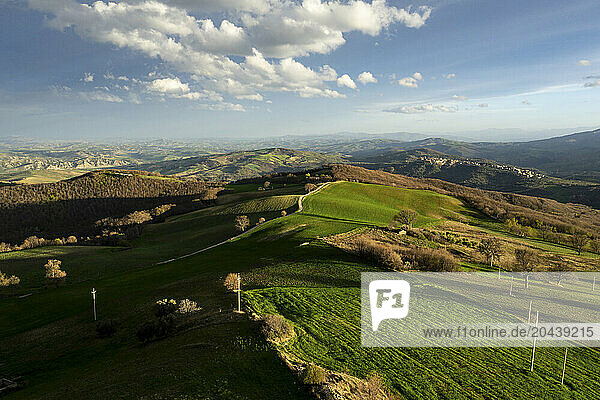 Green cultivated fields under cloudy sky on sunny day at Basilicata  Italy