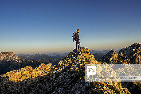 Young man standing on Steinfeldspitze rock at Altenmarkt  Zauchensee  Salzburg  Austria