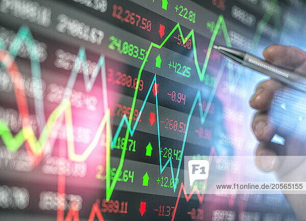 Hand of advisor checking stock market data on screen