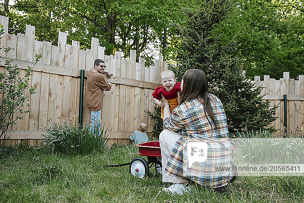 Family enjoying and working in back yard of farmhouse