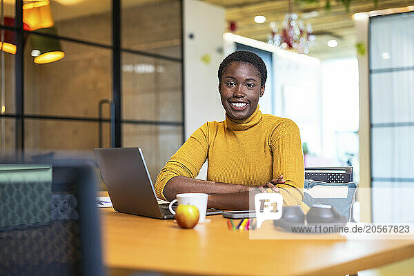 Confident businesswoman sitting at desk in office