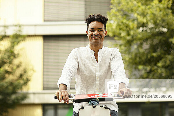 Happy man riding electric scooter at street