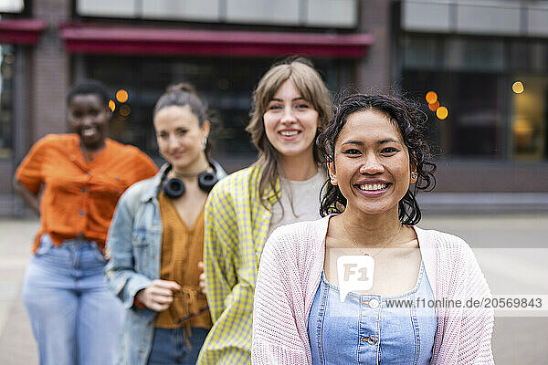 Smiling woman standing in front of friends