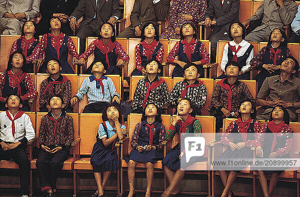 North Korea. Pyongyang. Children audience looking up (watching acrobats).