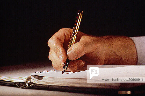 Business & Professions. Close up of man s hand  writing with fountain pen.