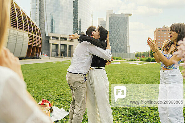 Cheerful couple hugging each other in front of buildings