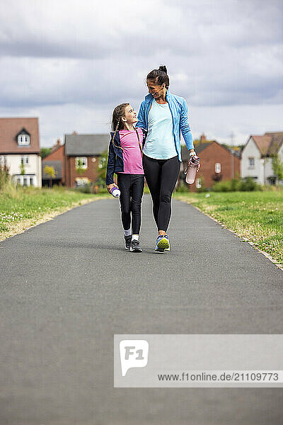 Daughter walking with mother on footpath