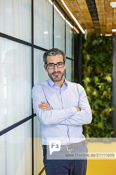 Businessman with eyeglasses standing at co working space