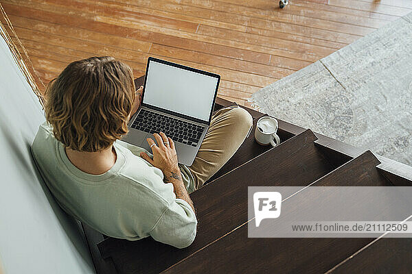 Young man working on laptop at home