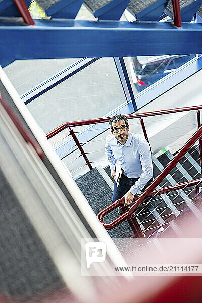 Businessman standing on staircase at co working space