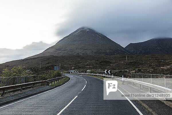 View of a winding road leading towards mountains in Isle of Skye  Scotland on an overcast day