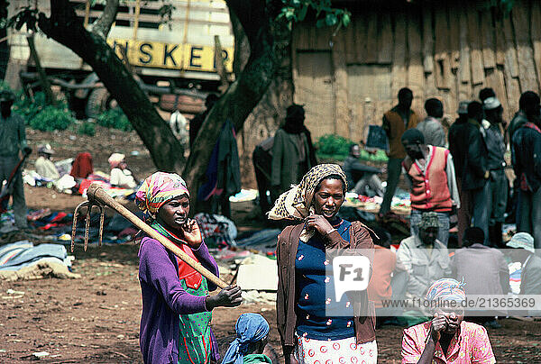Kenya. Women & crowd outdoors in the street.