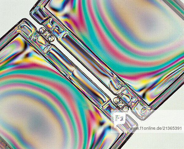 Science. Physics. Stress patterns in plastic box hinge photographed in polarized light.