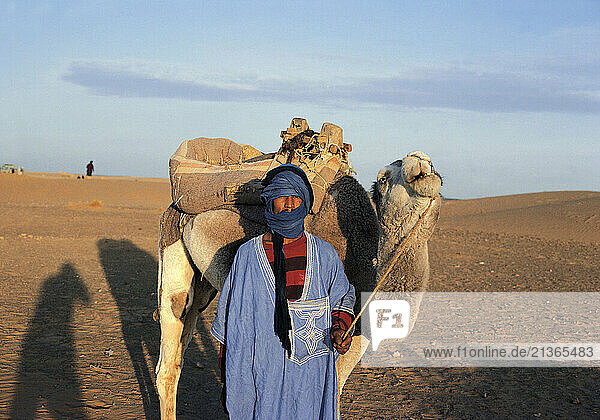 Morocco. Marrakech. Local man with his camel in the desert.
