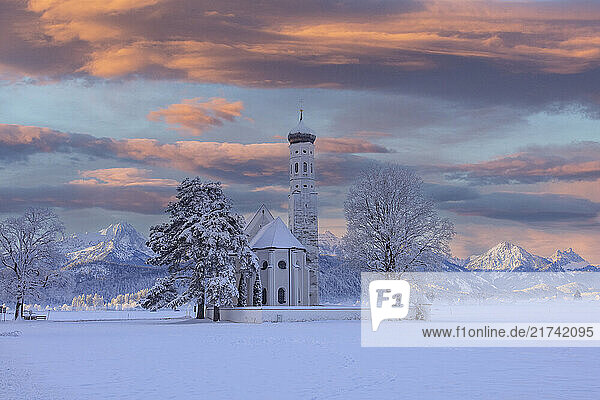 Blick auf Sankt Coloman in Schwangau im Winter mit Schnee  im Hintergrund die Allgäuer Alpen