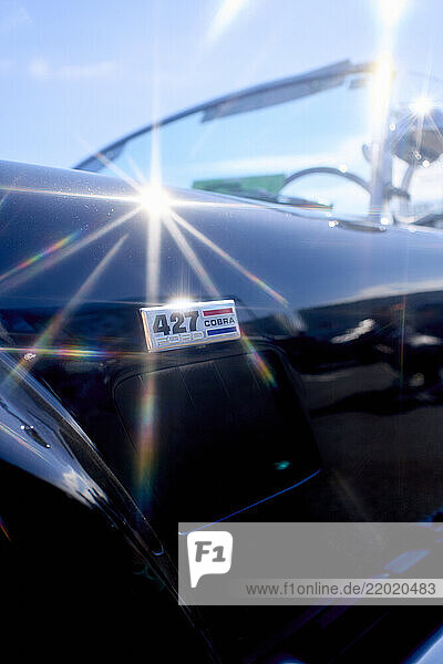 Shiny vintage car with 427 Cobra badge and sunlight reflections on the glossy surface. Tokyo  Japan
