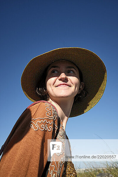 Woman in wide-brimmed hat smiling under a clear blue sky  Miami  Florida  USA