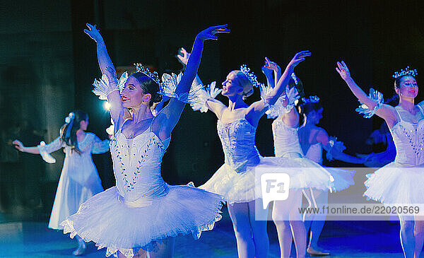 Ballet dancers in white tutus perform gracefully on a dimly lit stage. The Nutcracker  Bainbridge Island  USA
