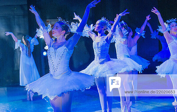 Ballet dancers in elegant white tutus performing on a stage under blue lighting. The Nutcracker  Bainbridge Island  USA