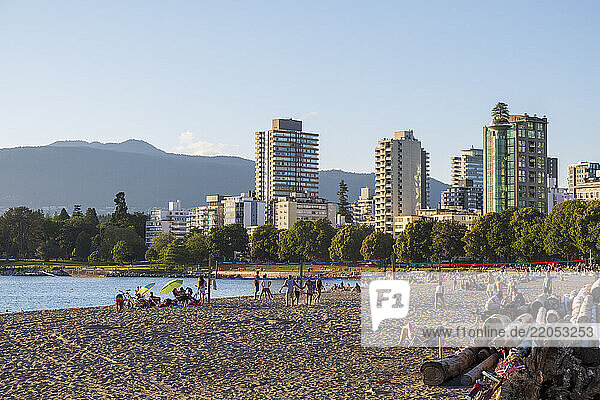 People on beach with high rise apartment buildings in background