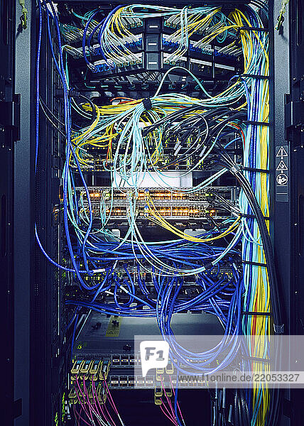Close-up of hard drives and tangled cables in data center