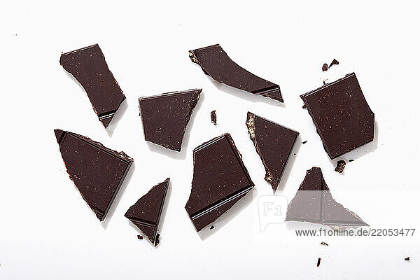 Broken pieces of chocolate on white background