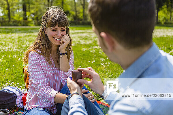 Young man proposing to his girlfriend in a park