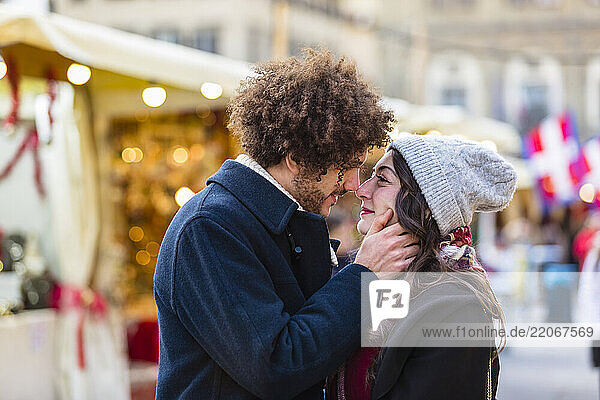 Affectionate young couple kissing at Christmas market