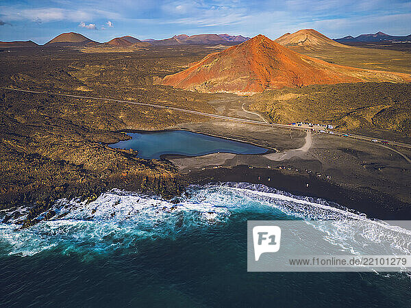 Spain  Canary Islands  Lanzarote. Small lake and beach in front of the Bermeja volcano
