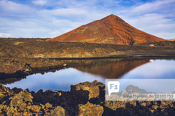 Spain  Canary Islands  Lanzarote. Small lake and beach in front of the Bermeja volcano