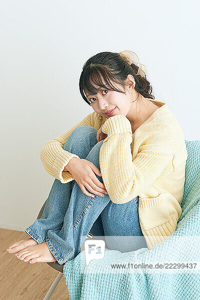 Japanese Woman Sitting On A Chair With Her Legs Crossed