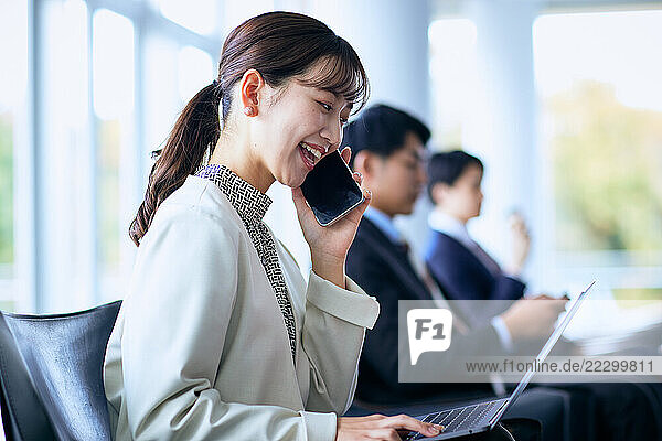 Japanese Woman Sitting On A Chair Talking On A Cell Phone