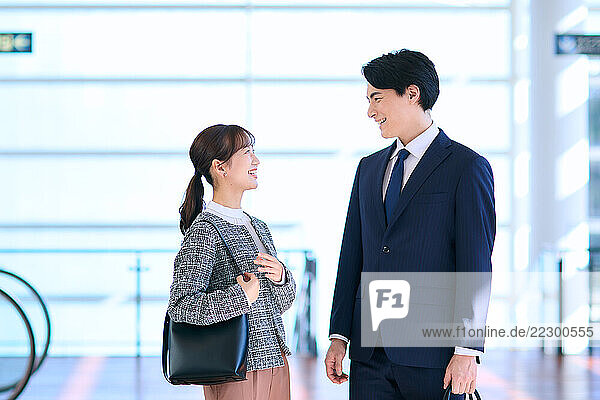 Japanese Man And Woman In Business Attire Talking