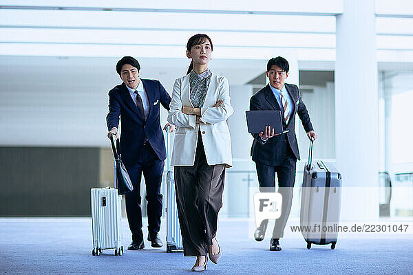 Three Business People Walking With Suitcases