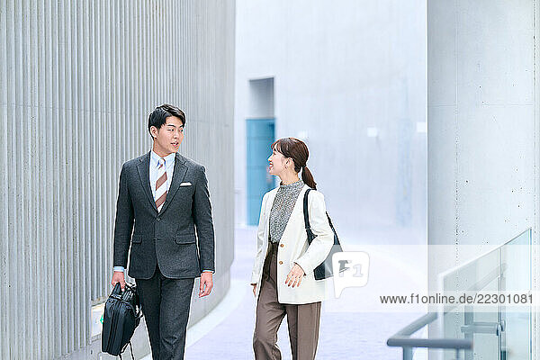 Japanese Business Couple Walking In A Corridor